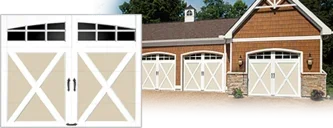 Clopay COACHMAN® Collection: A white and tan carriage house door with crossbuck overlays and arched windows, beside a house with three matching doors.