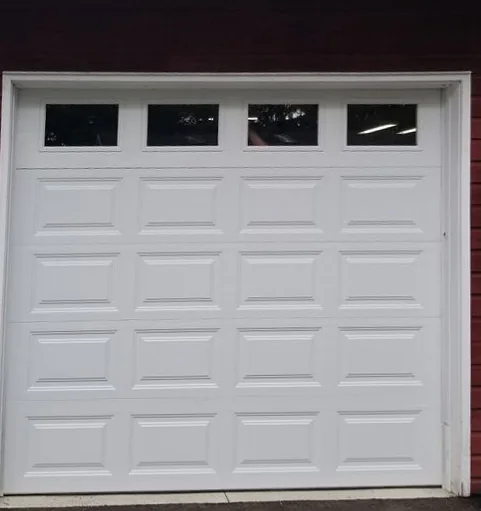 The same opening with a white raised-panel door and a row of four windows across the top section.